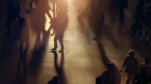 Crowds of people commuting in the city crossing street in rush hour traffic