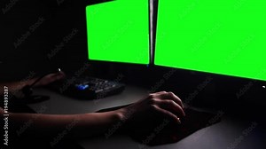 working with two monitors in dark, green screen
