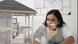 Young beautiful caucasian architect engineer turns house model around to inspect house construction and check mistake point to solve the problem on meeting table at modern office. Closeup. Immaculate. Stock Video