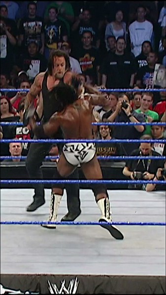 Booker T throws sand into Undertaker’s eyes, but the enraged Deadman immediately strikes back