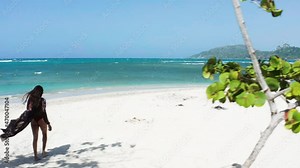 Aerial reveal of solo traveler exploring white sand beaches of Playa Teco Maimon outside of Puerto Plata, Dominican Republic