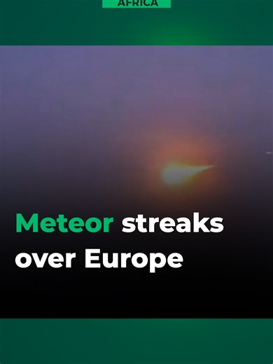 A meteor streaks across the night sky above the Netherlands and Germany, lighting up the horizon before burning up in the atmosphere.