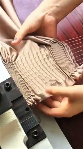 pleating brown fabric using an industrial smocking machine for professional garment production