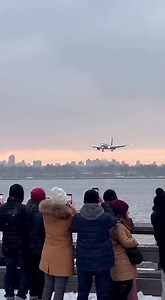 Passenger Jet Touches Down in Water During Emergency Landing New York City — A dramatic scene unfolded along the city’s waterfront when a passenger jet appeared to descend too low during its final approach and made contact with the water, triggering shock and confusion among dozens of onlookers gathered along the shoreline. The moment was captured on phones as the aircraft skimmed just above the surface before settling into the river. The video shows spectators lined up along a railing, watching