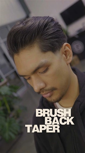 THE CUT EXPLAINED: Top Section: Maintained 3-4 inches of length with point-cut texturizing to remove bulk while keeping density. This allows the hair to brush back naturally without looking heavy or stiff. The key? Cutting with the grain and creating internal texture for movement. The Taper: Started with a mid-high guideline, blending from a #2 guard at the occipital bone down to skin. Used clipper-over-comb technique through the transition zone for that buttery smooth fade—no lines, just seamle