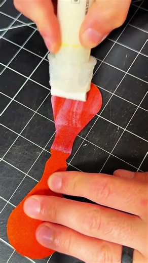 Applying white glue onto red crafted material
