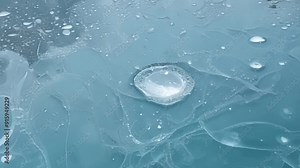 As the camera gets closer the bubbles ped in the frozen pond reveal an otherworldly beauty with delicate lines and swirls frozen in time.