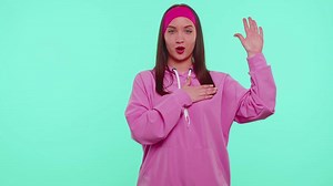 Sincere responsible teen girl raising hand to take oath, promising to be honest and to tell truth