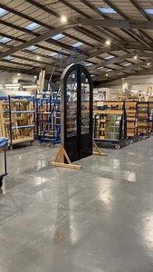 This imposing black arched front door is now in the finishing area of our manufacturing facilities, waiting to be transported to the West Coast of Scotland. We were contacted by the client earlier this year to manufacture a bespoke new front door that was double-glazed and highly secure. They sent us drawings from their architect to match the bespoke design that they were looking for. The customer chose a bespoke black paint finish, along with aged bronzed finished ironmongery, to complete their