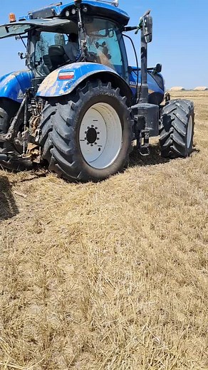 Blue Tractor Working in Dry Field with Loader