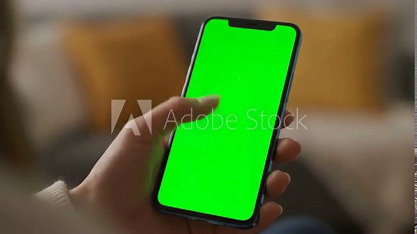 Green Screen Mockup with vertical feminine hand scrolling feed on smartphone mock up display female resting at home and checking social media mobile device close over the shoulder footage distortion
