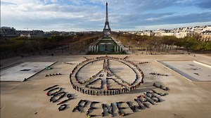 Hundreds of people just gathered at Paris’ 'Peace Wall' in front of the Eiffel Tower to send a message to the world. Art by John Quigley / Spectral Q | Greenpeace International