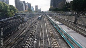4K High angle view landscape of Trains running on railway track arrival and departure from railway station platform in Tokyo city , Japan. Urban transportation and rail industry concept.