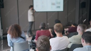 Speaker delivers a presentation to an attentive audience in a contemporary conference room. The setting highlights a professional and educational environment, ideal for seminars and workshops.