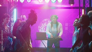 Persons having fun partying at club, enjoying breakdance battle with multiple people on dance floor. Friends showing off funky dance moves and clubbing in discotheque. Tripod shot.