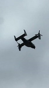 V22 Osprey tiltrotor shifts from flight to hover overhead