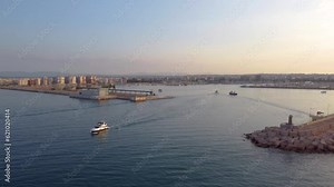 Early morning drone aerial footage around Torrevieja lighthouse when boats are leaving the marina and harbour