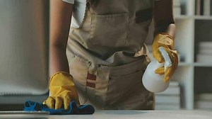 Download Housewife using vacuum cleaner on the floor. Wearing an apron to clean the living room at house. Young woman is happy to clean home. Maid cleaning service. for free