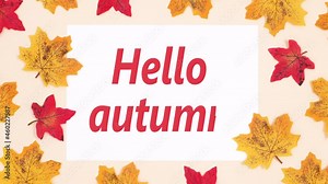 Hello autumn writing on paper surrounded by autumn leaves. Stop motion