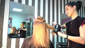 Professional Hair Dresser Used a hairdryer. Young woman getting her hair dressed in hair salon. Male stylist with a hairdryer. Hairdresser with hair dryer. Stacking. Hairdresser at work. Beauty saloon