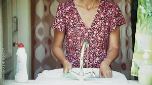 Woman washing dishes in sink at home, domestic chores