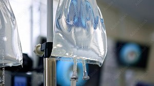 Drop counter bags filled with saline solution. Close up. Equipment in modern surgery room. Blurred backdrop.