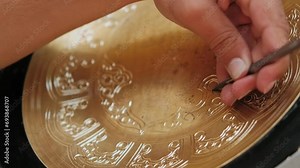 Master engraves patterns on a metal plate. Close-up, handmade, tinsmith, working with hammer during hand stamping or engraving decoration pattern on metal tray. Copper master, hands detail of Stock Video