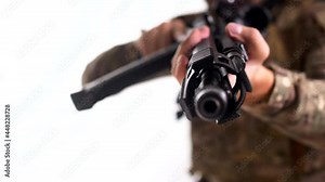 Military mercenary from a private military company aims an automatic rifle at the camera. The white background. Isolated
