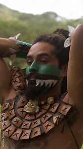 Man in body paint and traditional clothes with dreadlocks performing a traditional Mayan war dance, captured mid-movement in a lush green environment, embodying the ancient rituals of Mexico