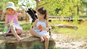 Little girls playing in the park on a hot Summer day.