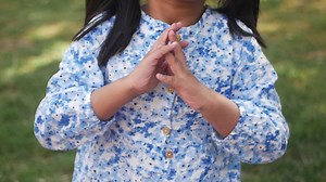 child clapping hands and smiling, sitting on sofa .