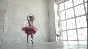 Ballerina performing pirouettes in studio. ballet dancer in a classic tutu and pointe