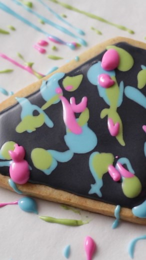 I love how these bold colors pop on the black background of these paint splatter inspired cookies 💖💙💚 This decorating technique can get pretty messy, but the result is worth it! #SweetAmbs #CookieArt #PaintSplatterCookies #NeonCookies #DecoratedCookies #CookieTutorial #EdibleArt #CookieArtClub #BakingFun #ColorfulCookies #RoyalIcing #DIYCookies #SweetTreats | SweetAmbs