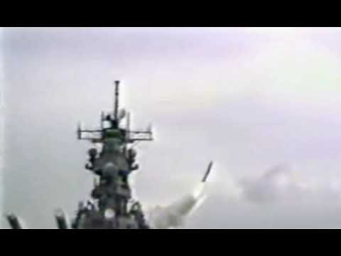 Iowa-class battleship firing 16 inch (406mm) guns and launching a tomahawk cruise missile.