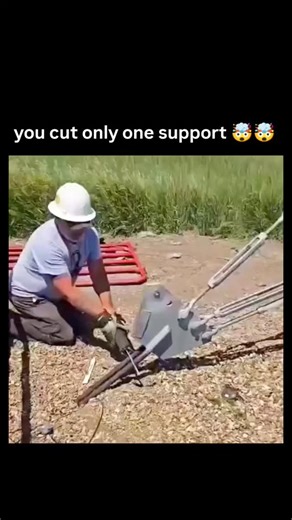 sci. || tech. on Instagram: "This is what happens if you cut only one support cable which holds tower . .The video captures a controlled demolition of a guyed telecommunications tower in a rural field, where a worker severs a base anchor cable, triggering an immediate and directional collapse due to the unbalanced pull from intact guy wires. Structurally, guyed towers resist wind via symmetric cable tension; cutting one creates a lateral bending moment that buckles the mast, as modeled in engine