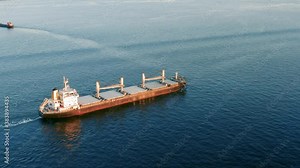 Cargo ship sailing on the ocean to the sea port. A bulk carrier or bulker - a merchant ship specially designed to transport unpackaged bulk cargo, such as grains, ore, coal or timber