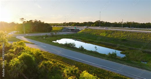 Freeway interchange system in Florida with exit ramps and high-speed traffic flow at sunset.