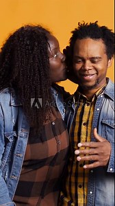 Vertical Video Affectionate romantic wife whispering intimate things to her husband, caressing and telling a secret into his ear. Cute optimistic couple flirting with each other, laughing in studio