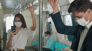 Close up businessman standing on the seat using modern smartphone to internet checking news on electric train, Passenger young man commuting texting on mobile phone by railway transport