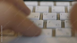 fingers of a Russian programmer or hacker typing on a white computer keyboard with Cyrillic letters