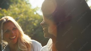 Three smiling mature female friends outdoors talking as they walk in countryside together - shot in slow motion