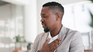 Black man, office and asthma, inhaler for breathing, help with chest pain from illness or allergy. Breathe, inhale and businessman with health problem, emergency pump and air relief in lungs at desk.