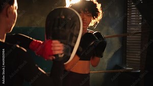 Women self defense power. Woman fighter boxer and personal trainer training in gym teaching mma fitness punching with boxing gloves. Healthy strong girl punching training punches. Fit body workout