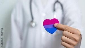 Bisexuality Celebrate Day and LGBT pride month, LGBTQ+ or LGBTQIA+ concept. Doctor holding purple, pink and blue heart shape for Lesbian, Gay, Bisexual, Transgender, Queer and Pansexual community