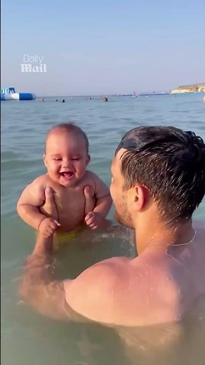 Baby belly laughing at the beach