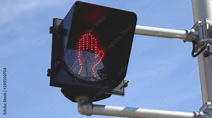 crosswalk sign changing from led person to led flashing red stop hand sign.