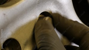 Close up of a car tire while the mechanic finger tightens the bolt on a wheel