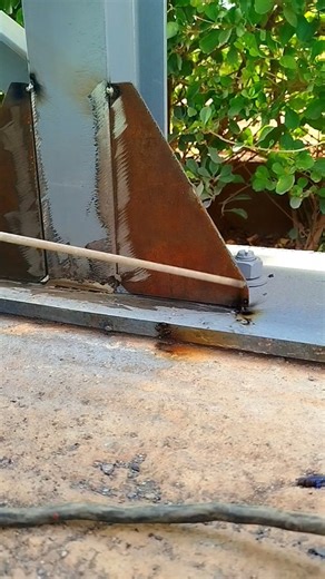 a welded joint on the base of a post and a metal structure. a triangular plate (gusset plate).#weld