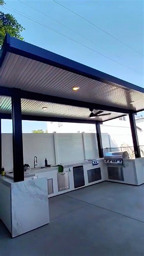 BBQ Islands & Designs on Instagram: "A backyard built for hosting, easy mornings, breezy afternoons, and long nights around the grill 🔥🌿 This outdoor kitchen brings everything together in one clean, modern layout. Under the patio cover, the whole family gets to cook, prep, serve, and hang out in one comfortable space; shade, airflow, and all the essentials within arm’s reach. The U-shaped BBQ island features a powerful Lion L90000 grill, a side burner for sauces and sides, a built-in ice chest