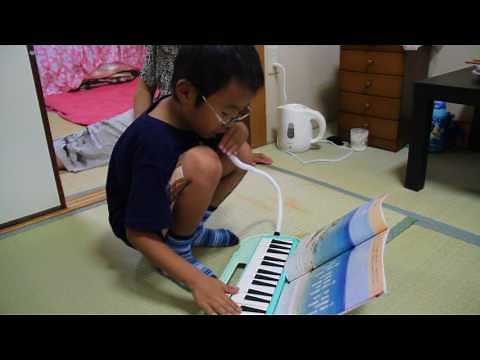 A child playing a melodica, (a breath powered "face piano")
